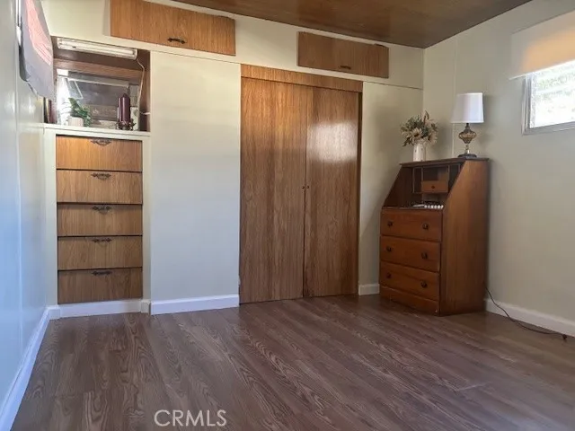 an empty room with cabinet and wooden floor