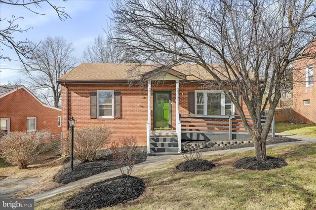 a front view of a house with a yard covered with snow