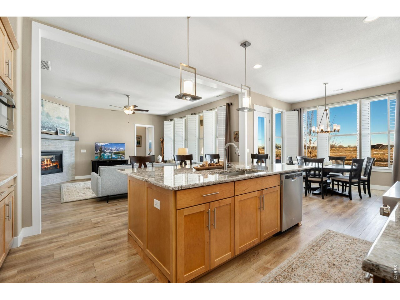 1030 Larimer Ridge Parkway Timnath, CO 80547 - Photo 12 of 38 a kitchen with stainless steel appliances granite countertop sink wooden floor dining table and chairs