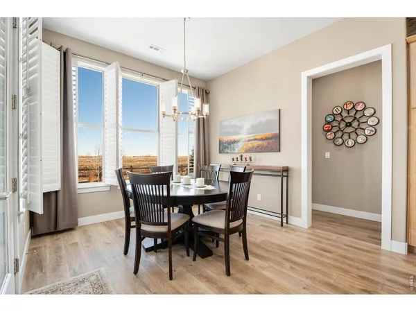 a kitchen with stainless steel appliances kitchen island granite countertop a dining table chairs refrigerator and microwave