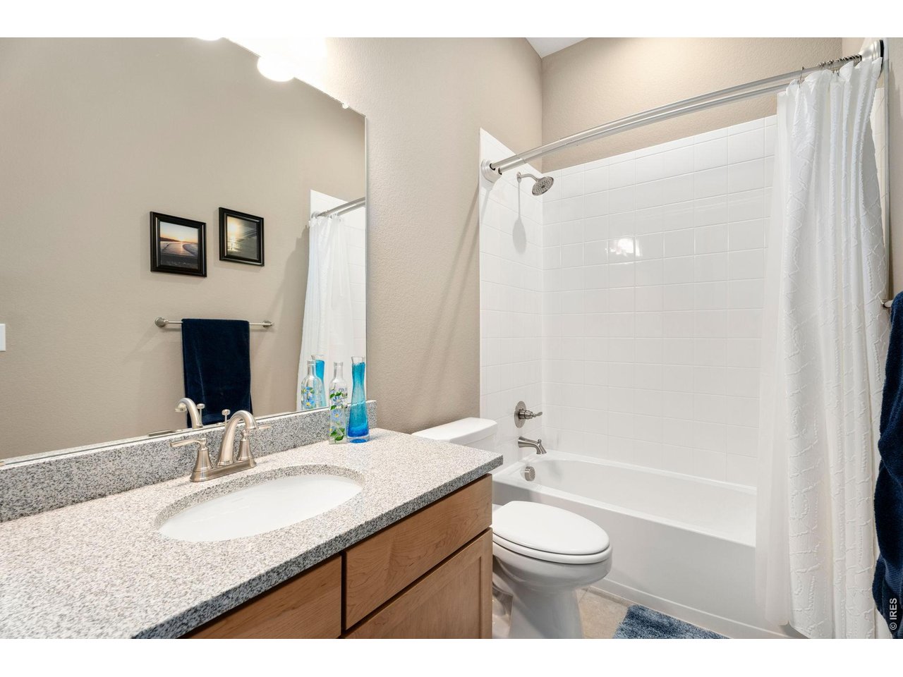 1030 Larimer Ridge Parkway Timnath, CO 80547 - Photo 19 of 38 a bathroom with a granite countertop sink toilet a large mirror and shower