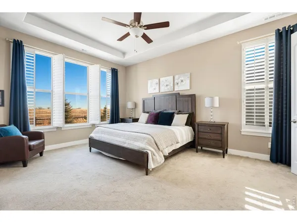 a bedroom with a large bed and ceiling fan