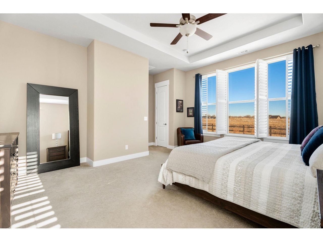 1030 Larimer Ridge Parkway Timnath, CO 80547 - Photo 27 of 38 a bedroom with a large bed and ceiling fan