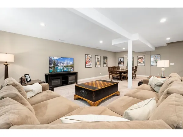 a living room with furniture pool table and a flat screen tv