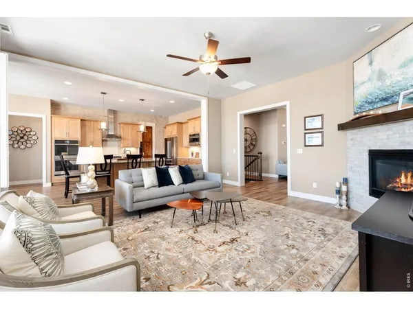 a open kitchen with stainless steel appliances granite countertop a dining table chairs and white cabinets