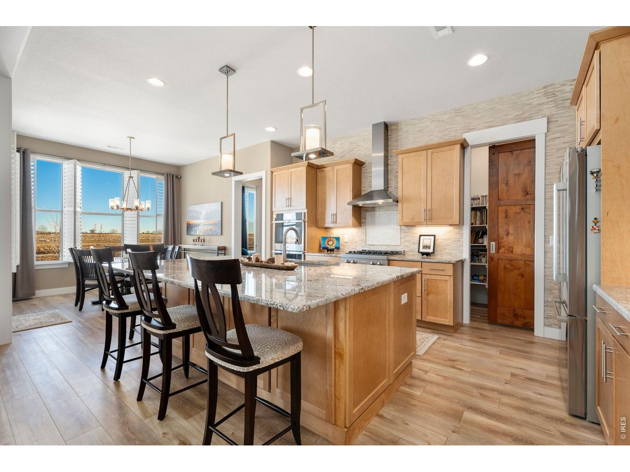 1030 Larimer Ridge Parkway Timnath, CO 80547 - Photo 10 of 38 a open kitchen with stainless steel appliances granite countertop a dining table chairs and white cabinets