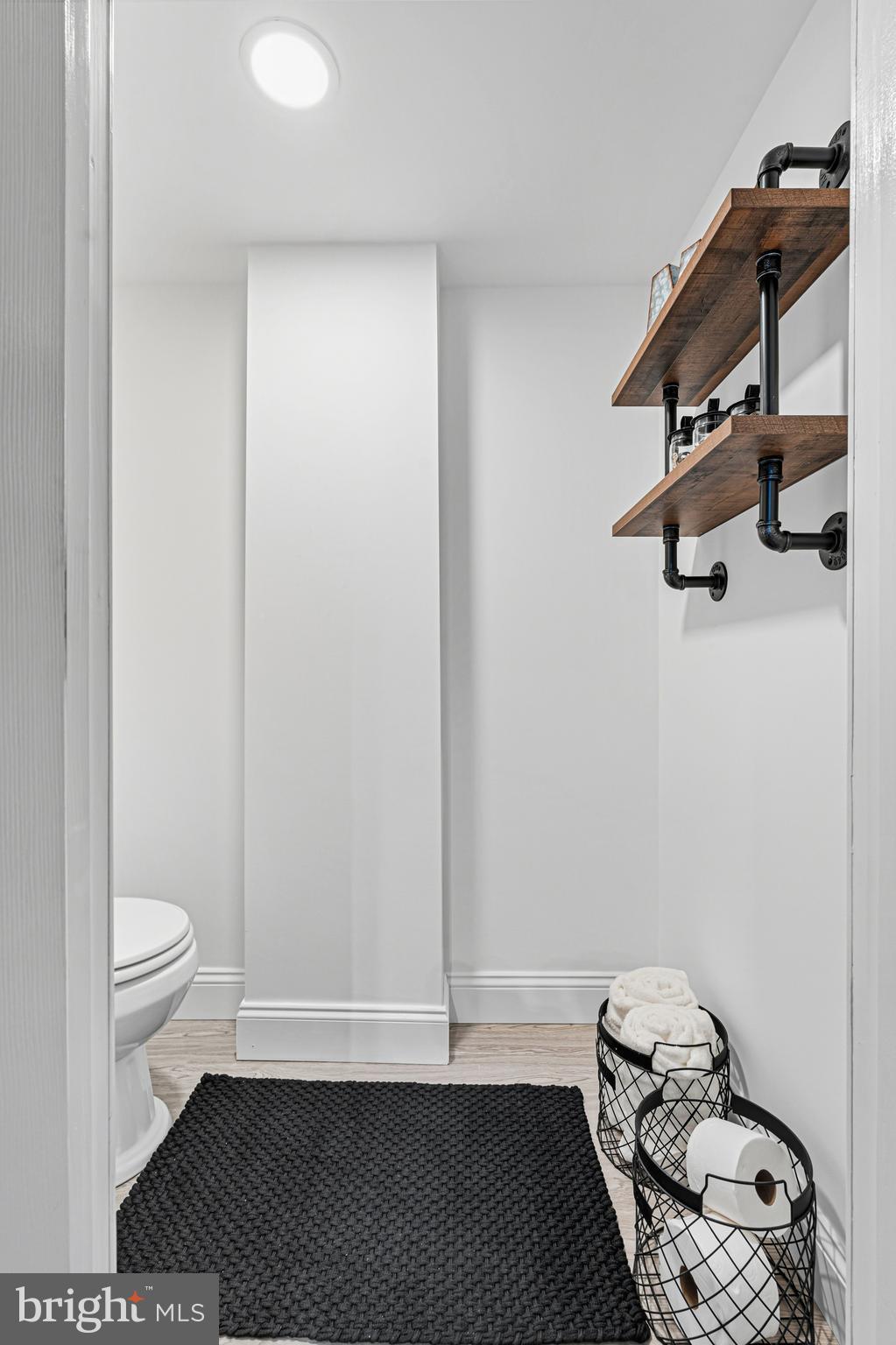 7815 Rockbourne Road Baltimore, MD 21222 - Photo 34 of 39 a view of a hallway with wooden floor and a bathroom
