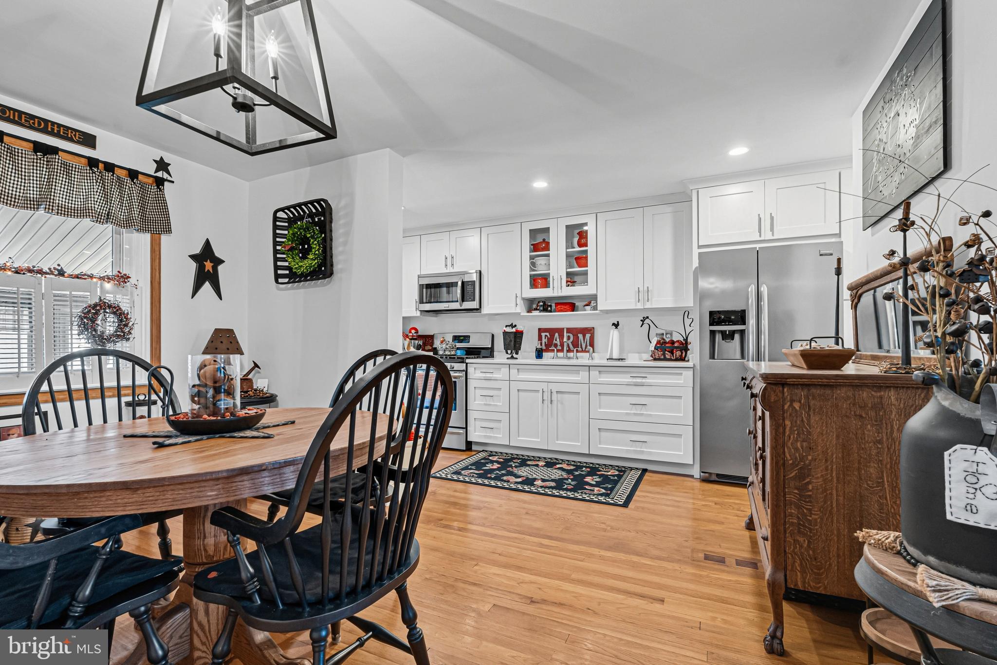 7815 Rockbourne Road Baltimore, MD 21222 - Photo 9 of 39 a kitchen with stainless steel appliances kitchen island granite countertop a table chairs in it and wooden floors