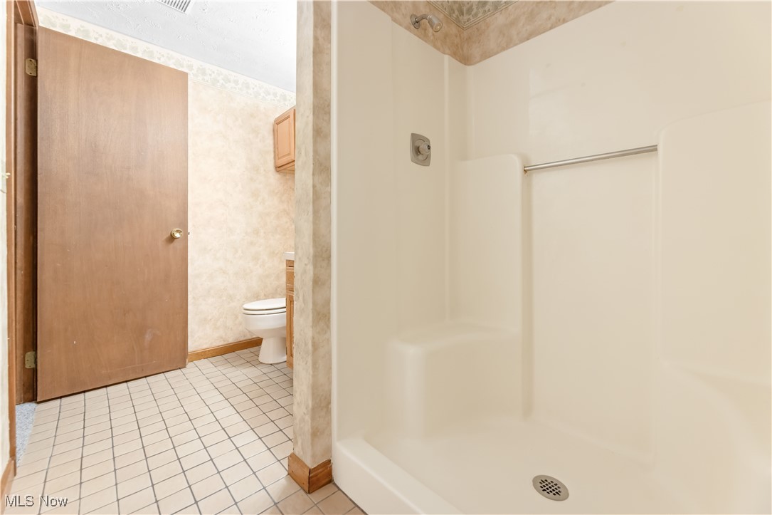 1574 Faye Road Akron, OH 44306 - Photo 29 of 45 Bathroom with tile patterned flooring, a shower, and toilet