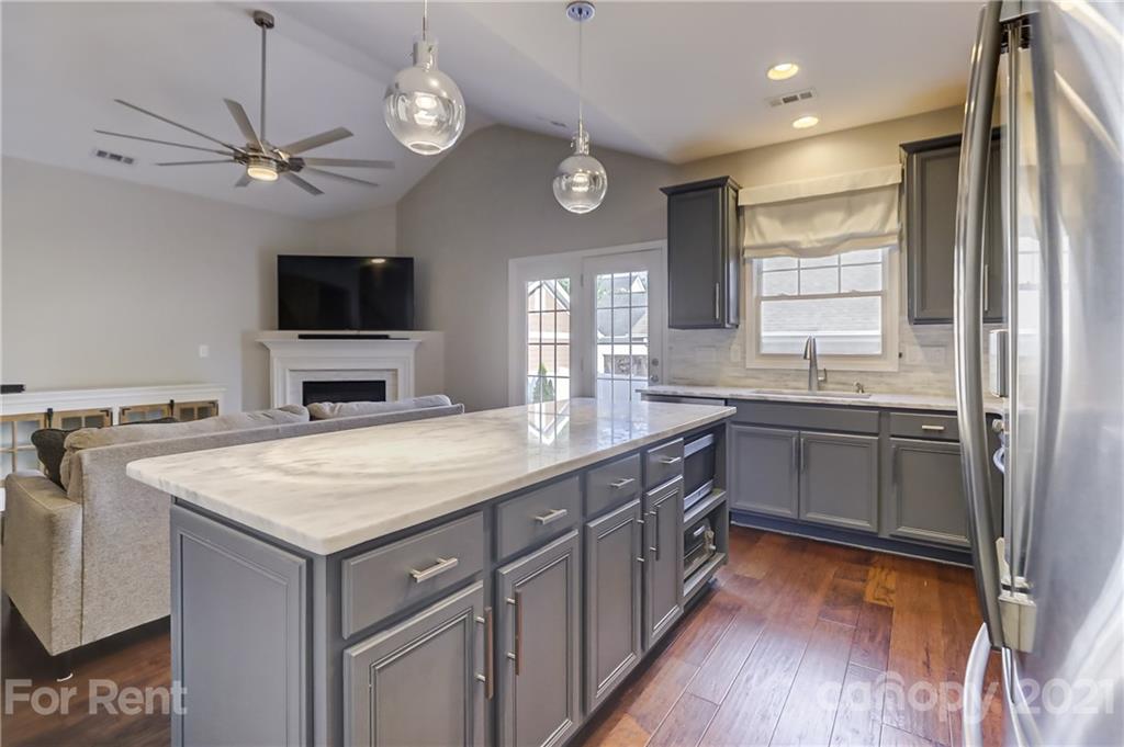 1033 Market Street Fort Mill, SC 29708 - Photo 12 of 46 a kitchen with a center island wooden floor and stainless steel appliances