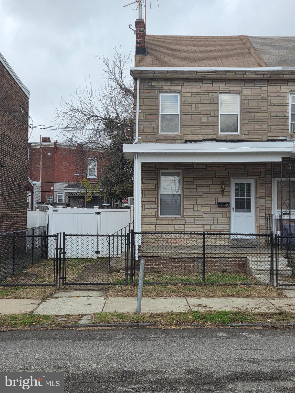 6736 Vandike Street Philadelphia, PA 19135 - Photo 1 of 18 a view of a brick house with a white fence
