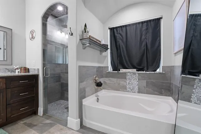 a bathroom with a tub a sink and a mirror