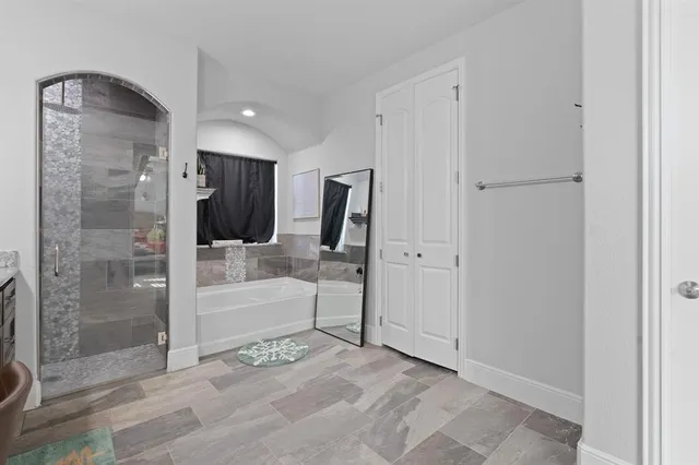 a bathroom with a glass shower door and a glass door