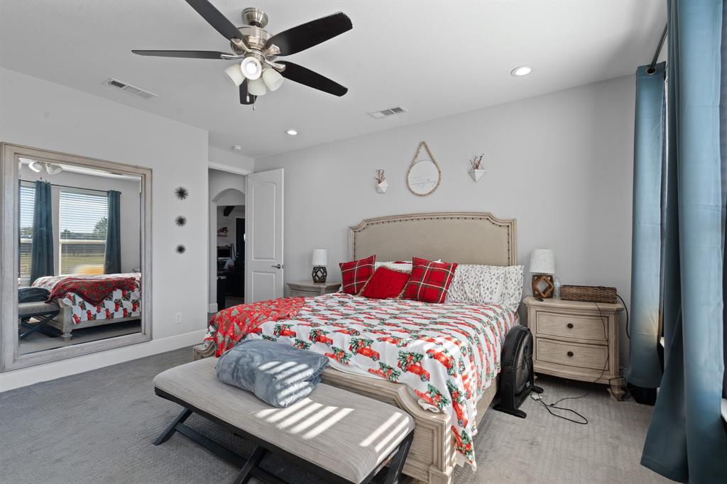 6033 Berry Ridge Lane Joshua, TX 76058 - Photo 22 of 39 a bedroom with a bed and a chandelier