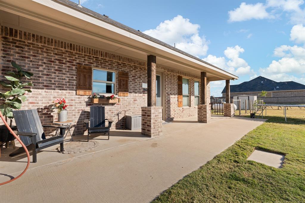 6033 Berry Ridge Lane Joshua, TX 76058 - Photo 25 of 39 a view of a patio with table and chairs under an umbrella