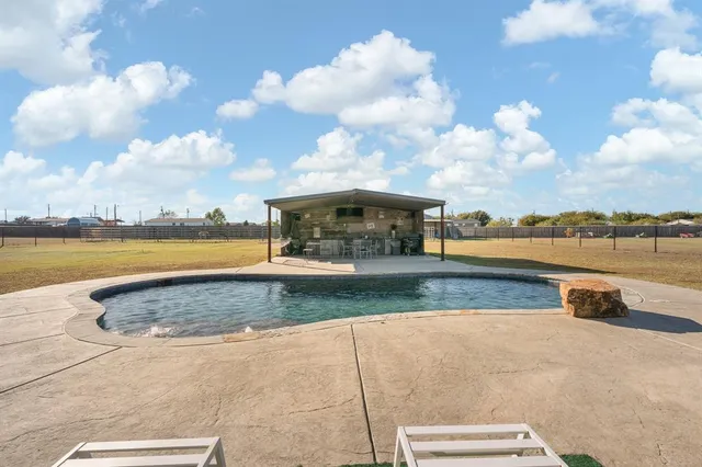 a view of swimming pool with outdoor seating and yard in back