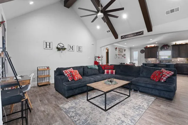 a living room with furniture and a wooden floor