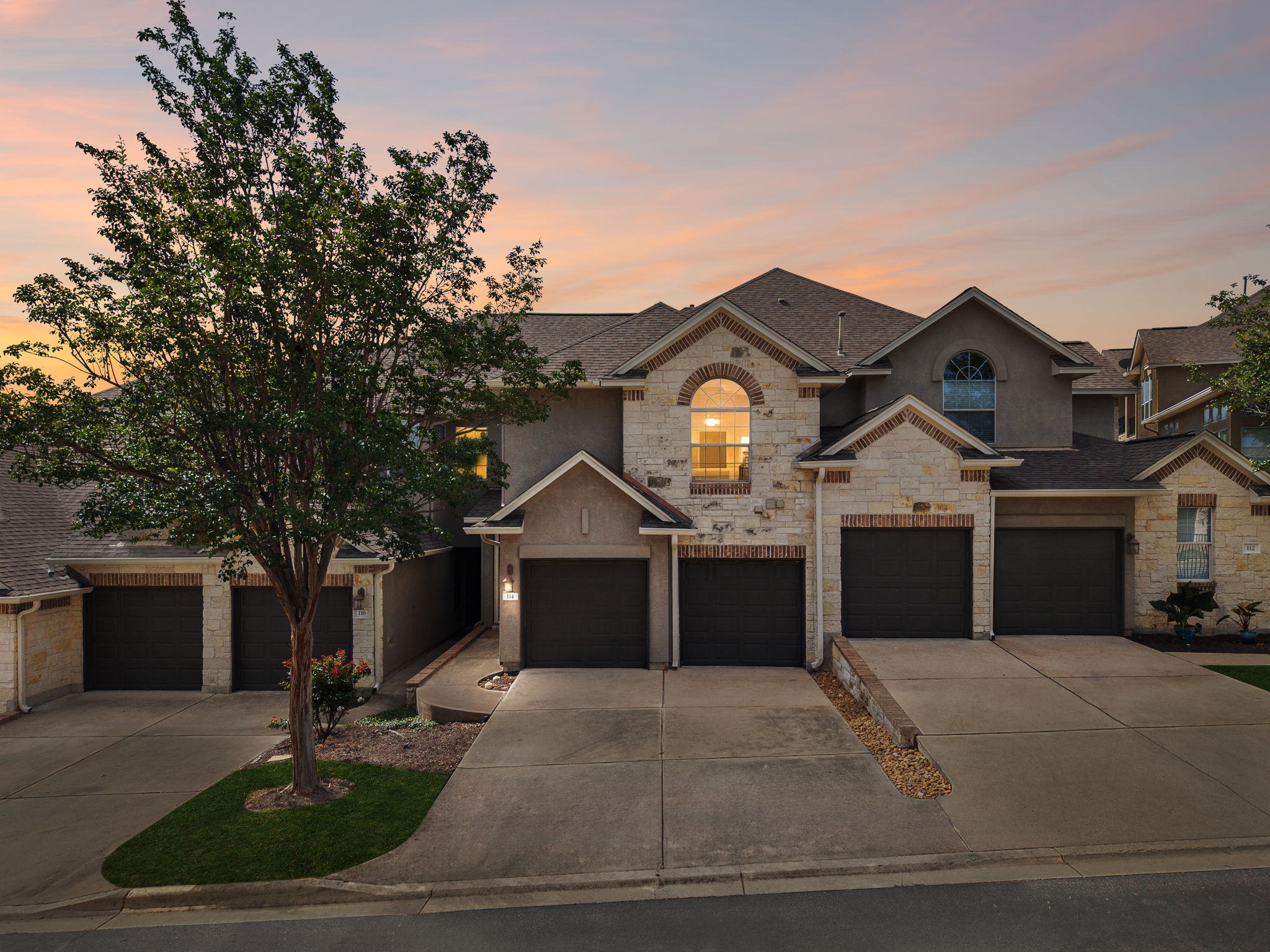 114 Aria Ridge, Unit 802 Lakeway, TX 78738 - Photo 37 of 37 Stone and stucco facades define this contemporary townhouse community at sunset.