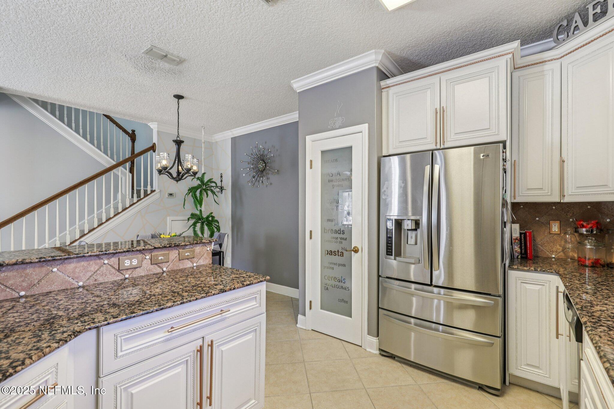 1693 Sanctuary Way Fleming Island, FL 32003 - Photo 13 of 33 a kitchen with granite countertop a refrigerator and a sink