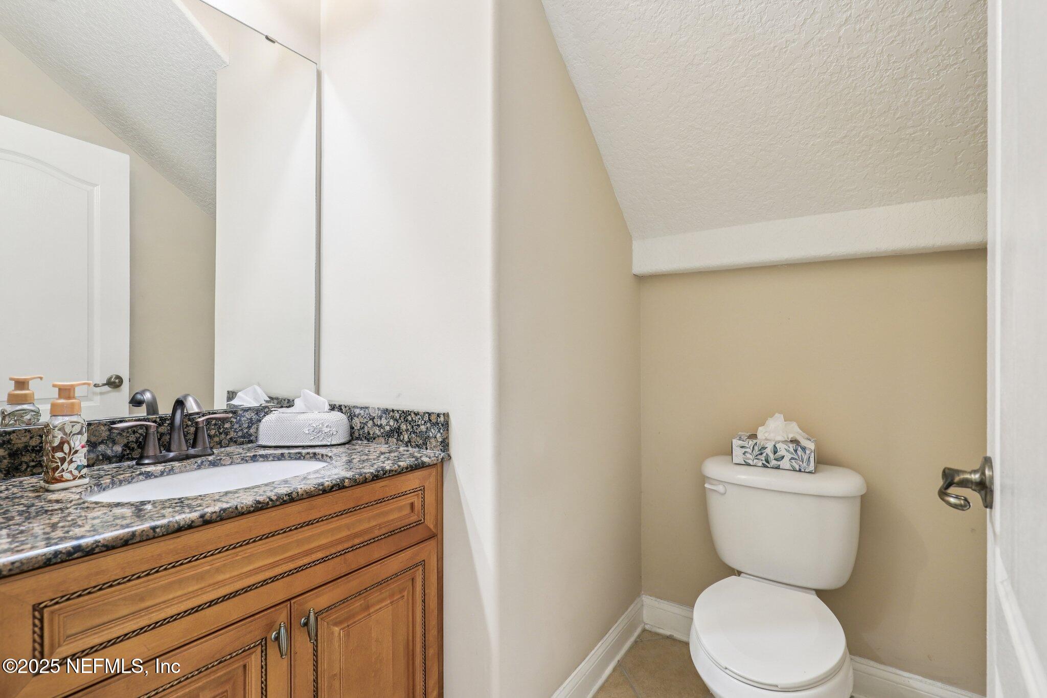 1693 Sanctuary Way Fleming Island, FL 32003 - Photo 14 of 33 a bathroom with a toilet sink and mirror