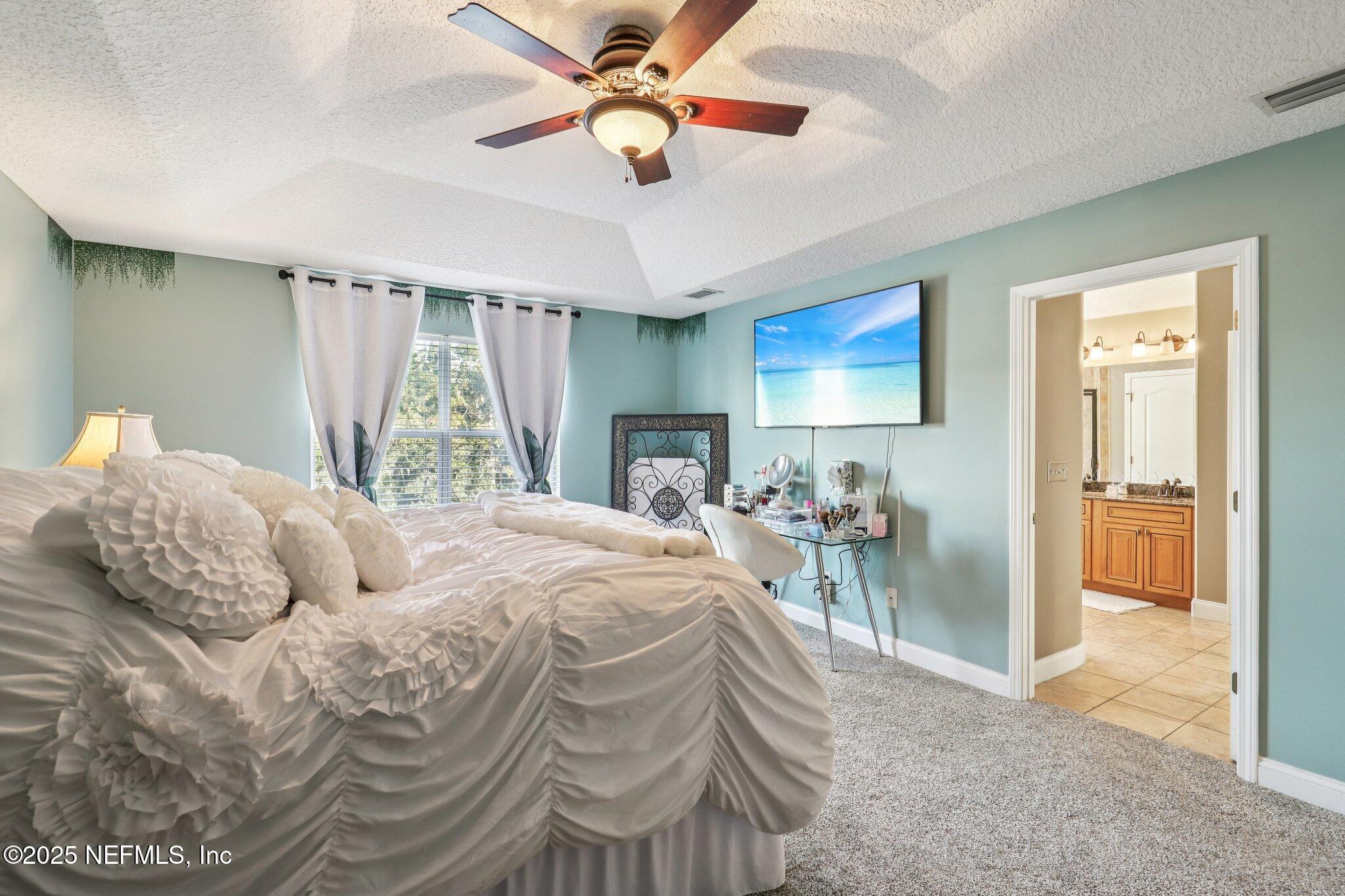 1693 Sanctuary Way Fleming Island, FL 32003 - Photo 17 of 33 a bedroom with a bed and a chandelier