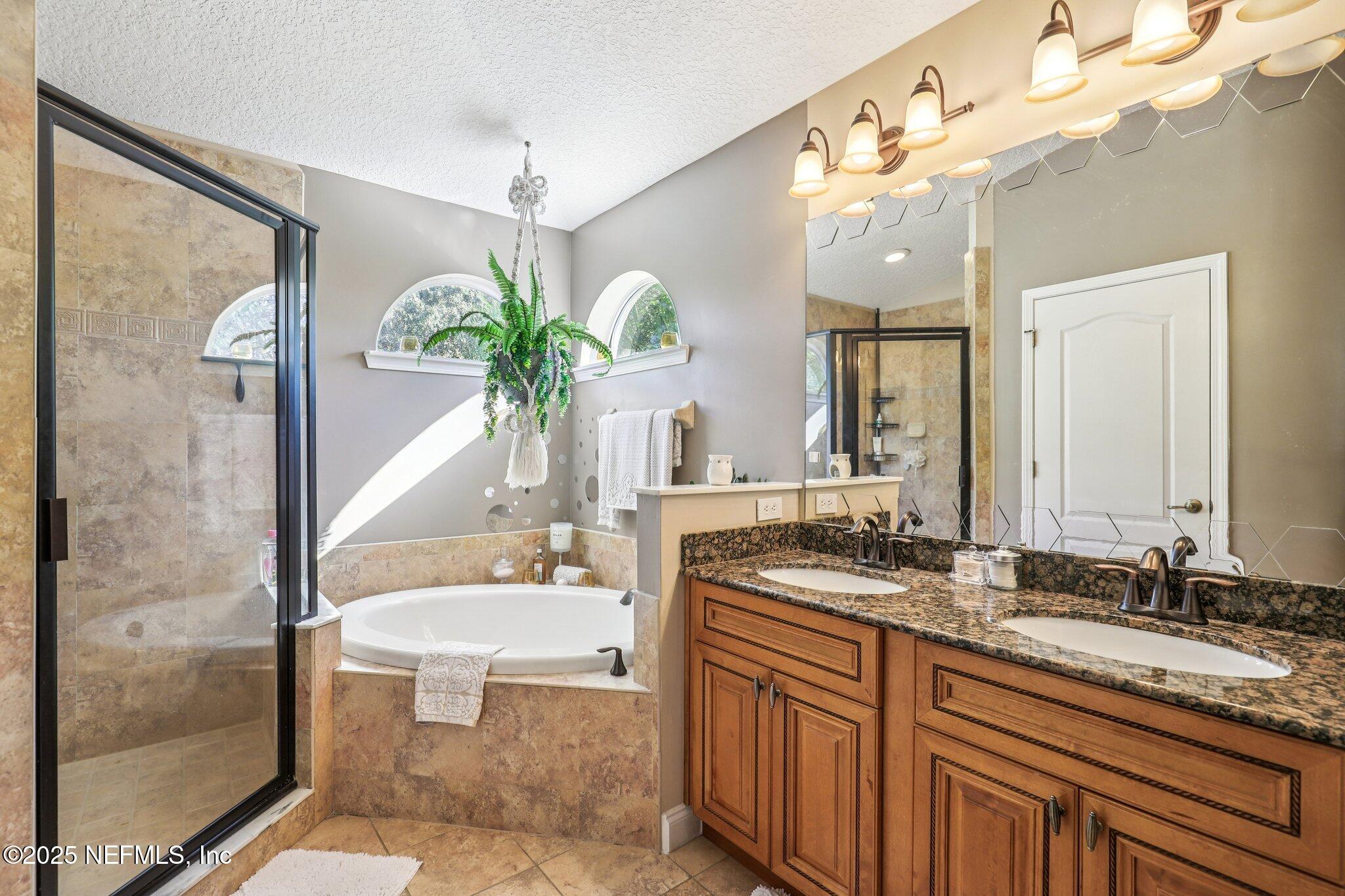 1693 Sanctuary Way Fleming Island, FL 32003 - Photo 18 of 33 a bathroom with a granite countertop sink a mirror and a shower
