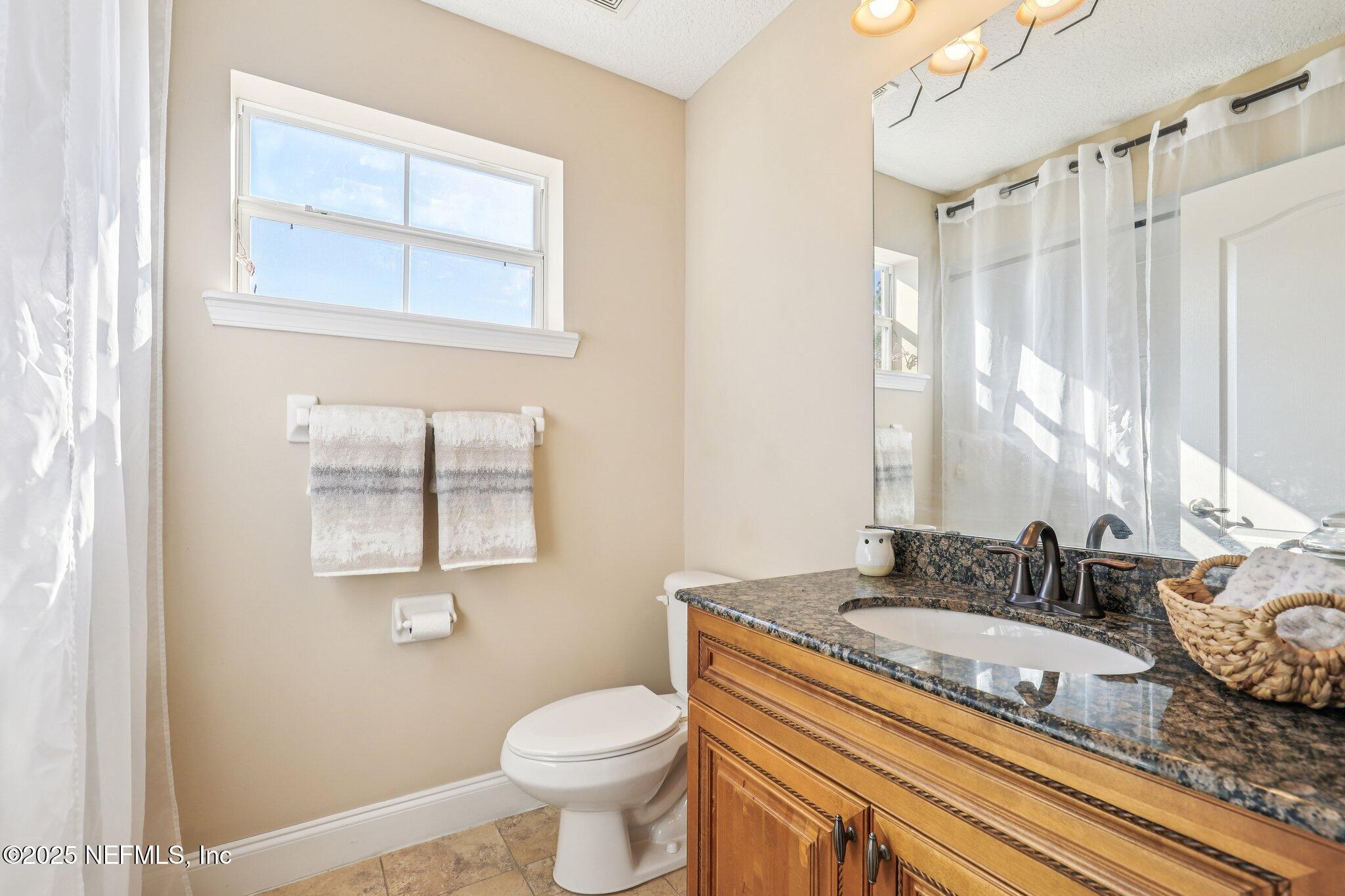 1693 Sanctuary Way Fleming Island, FL 32003 - Photo 21 of 33 a bathroom with a granite countertop sink and a mirror
