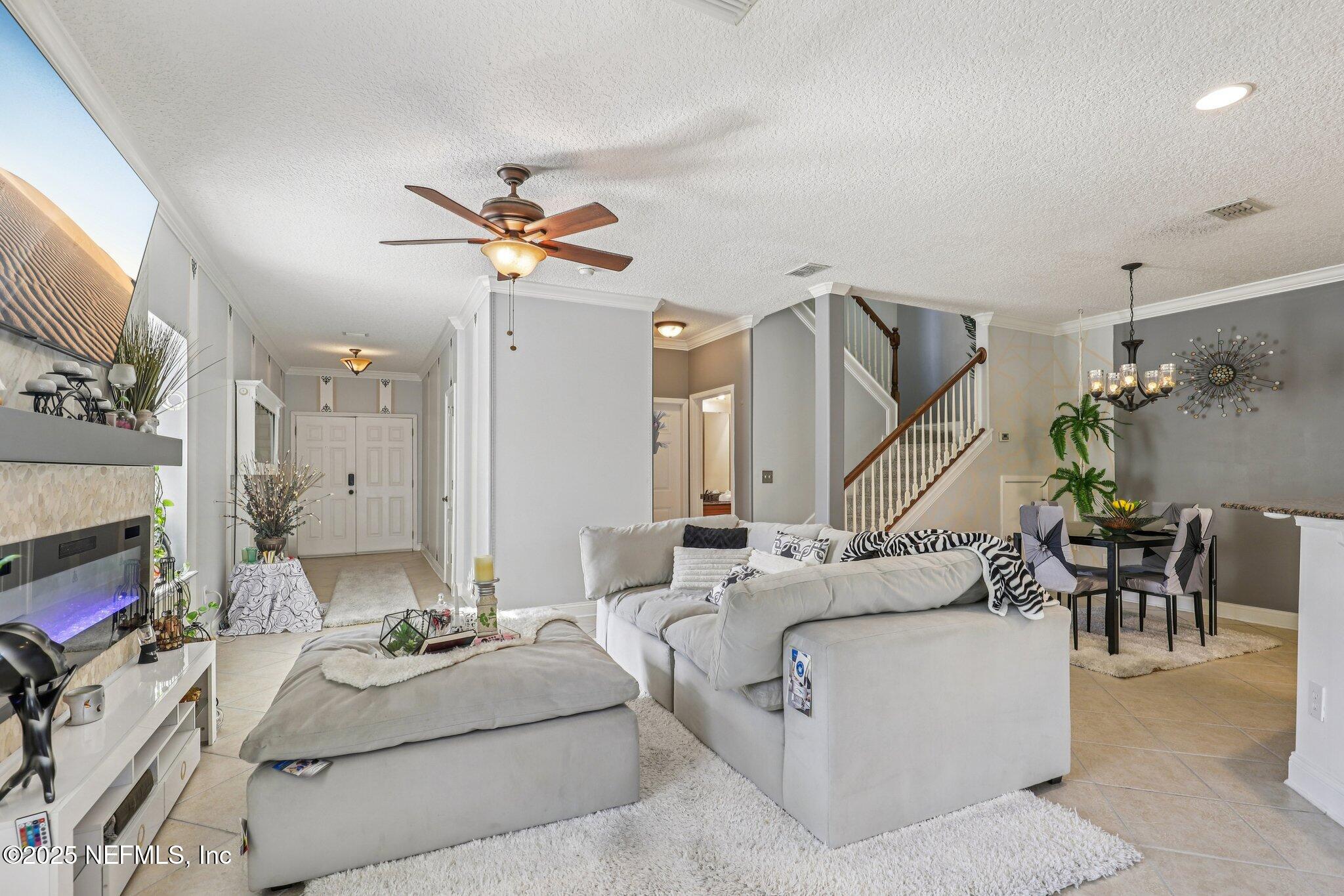 1693 Sanctuary Way Fleming Island, FL 32003 - Photo 6 of 33 a living room with furniture and a chandelier