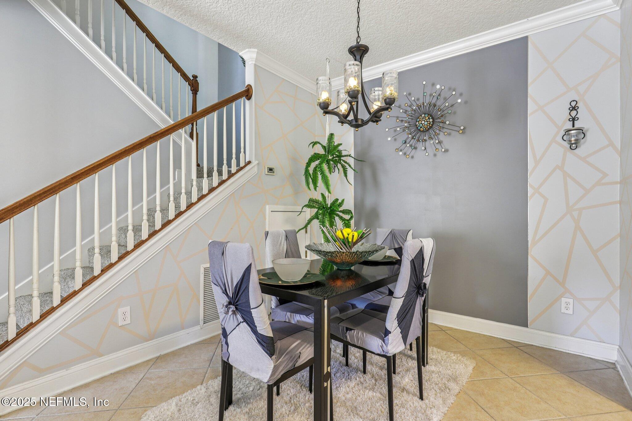 1693 Sanctuary Way Fleming Island, FL 32003 - Photo 9 of 33 a view of a dining room with furniture a chandelier and wooden floor