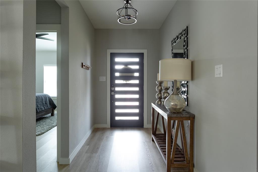 1108 Claude Street Dallas, TX 75203 - Photo 2 of 17 Entryway featuring wood-finish flooring and a contemporary black door with frosted glass panels