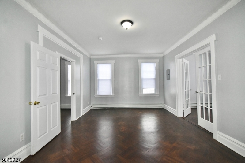 519 Clinton Place, Unit 2R Newark, NJ 07112 - Photo 1 of 15 an empty room with wooden floor and windows