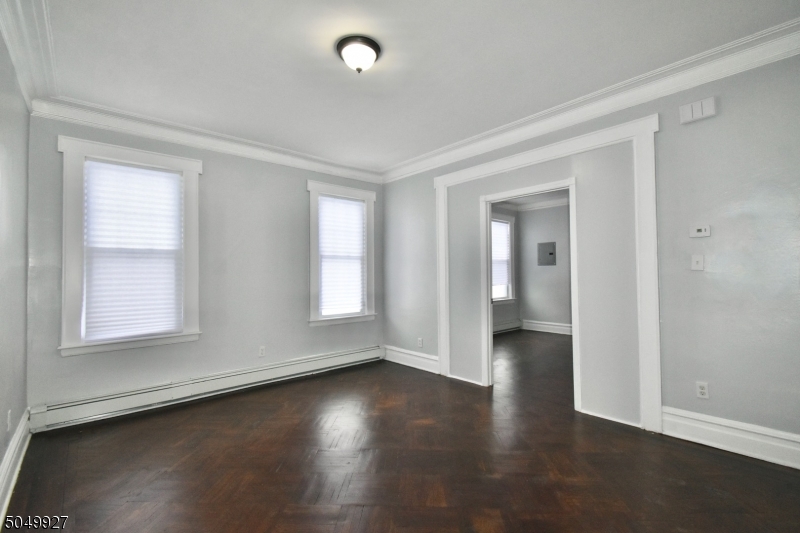 519 Clinton Place, Unit 2R Newark, NJ 07112 - Photo 4 of 15 an empty room with wooden floor and windows