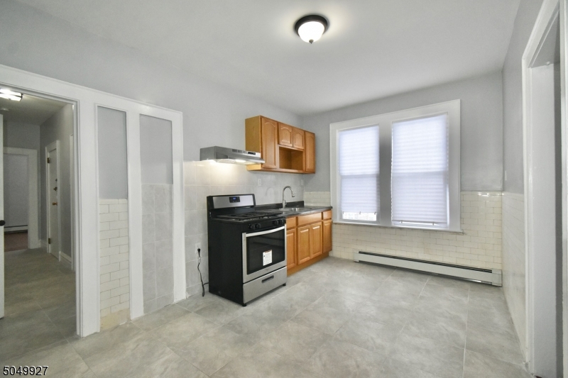 519 Clinton Place, Unit 2R Newark, NJ 07112 - Photo 6 of 15 a kitchen with granite countertop a stove a sink and a refrigerator