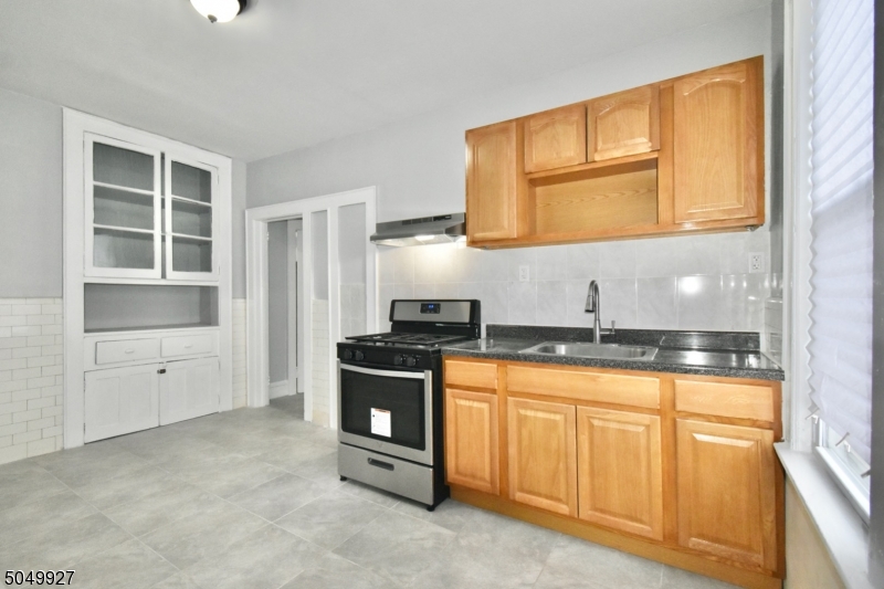 519 Clinton Place, Unit 2R Newark, NJ 07112 - Photo 7 of 15 a kitchen with granite countertop a stove a sink and a microwave