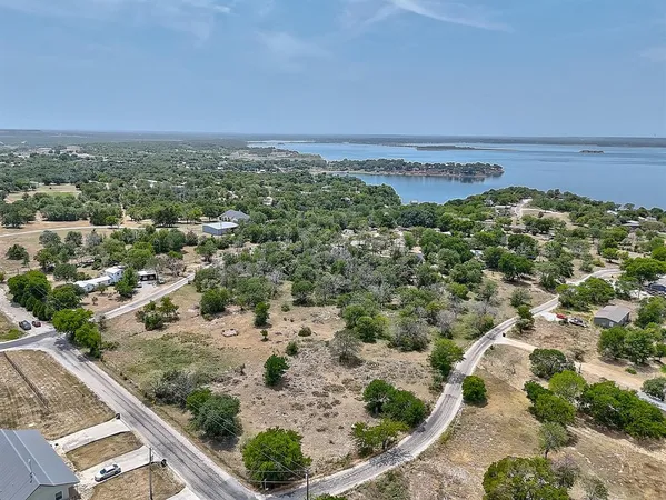an aerial view of a house with a yard and lake view