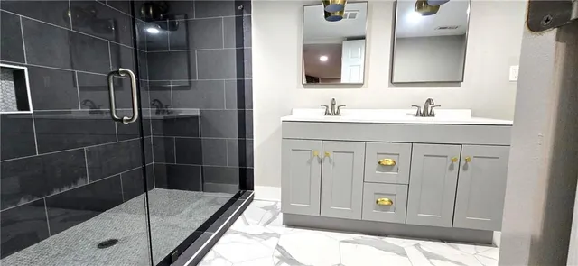 a bathroom with a shower sink and mirror