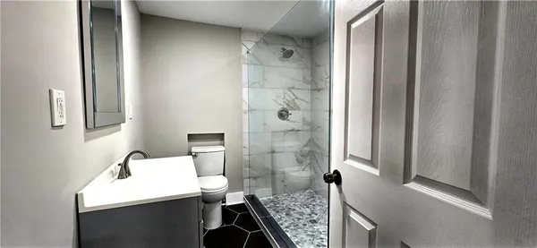 a bathroom with a sink a toilet and shower