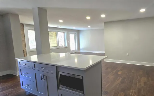 an open kitchen with granite countertop a sink and a large window