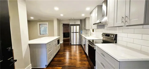a kitchen with a sink a counter top space stainless steel appliances and cabinets