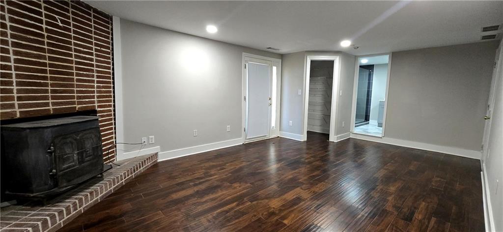 3594 Abbotts Bridge Road Duluth, GA 30096 - Photo 10 of 30 a view of an empty room with wooden floor and a fireplace