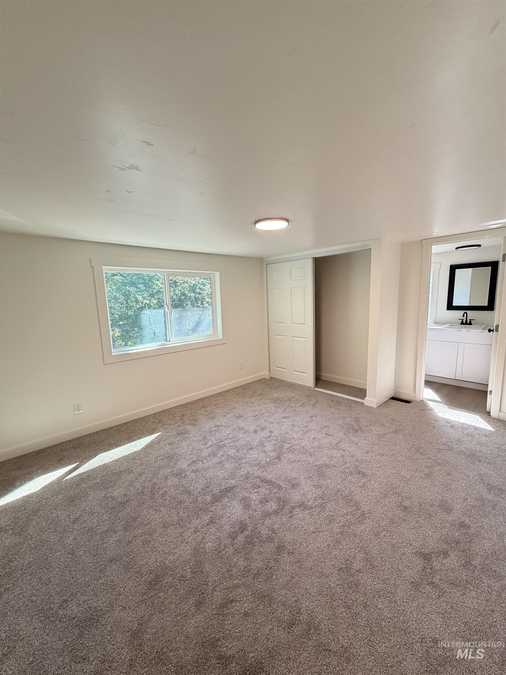 151 View Road Kamiah, ID 83536 - Photo 21 of 49 Spacious room featuring neutral carpeting, a window providing natural light, and a built-in closet with bi-fold doors