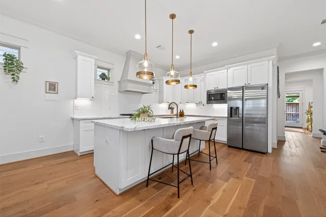 a bathroom with a granite countertop sink a mirror and shower