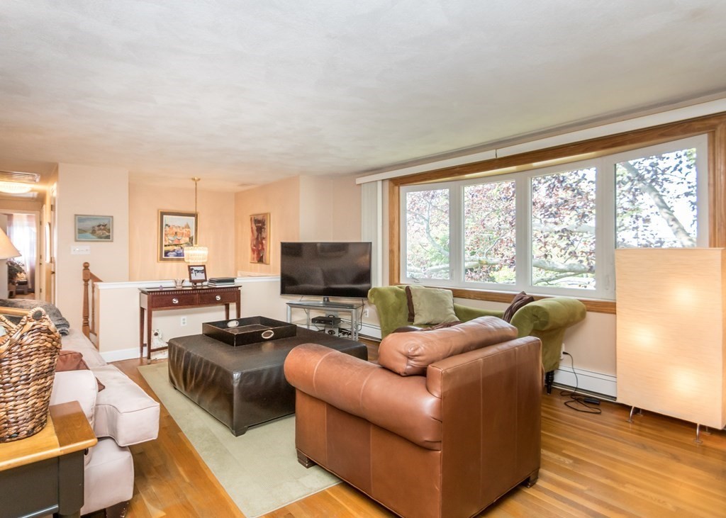 43 Alfreton Road Needham, MA 02494 - Photo 2 of 34 a living room with furniture floor to ceiling window hardwood floor and a flat screen tv