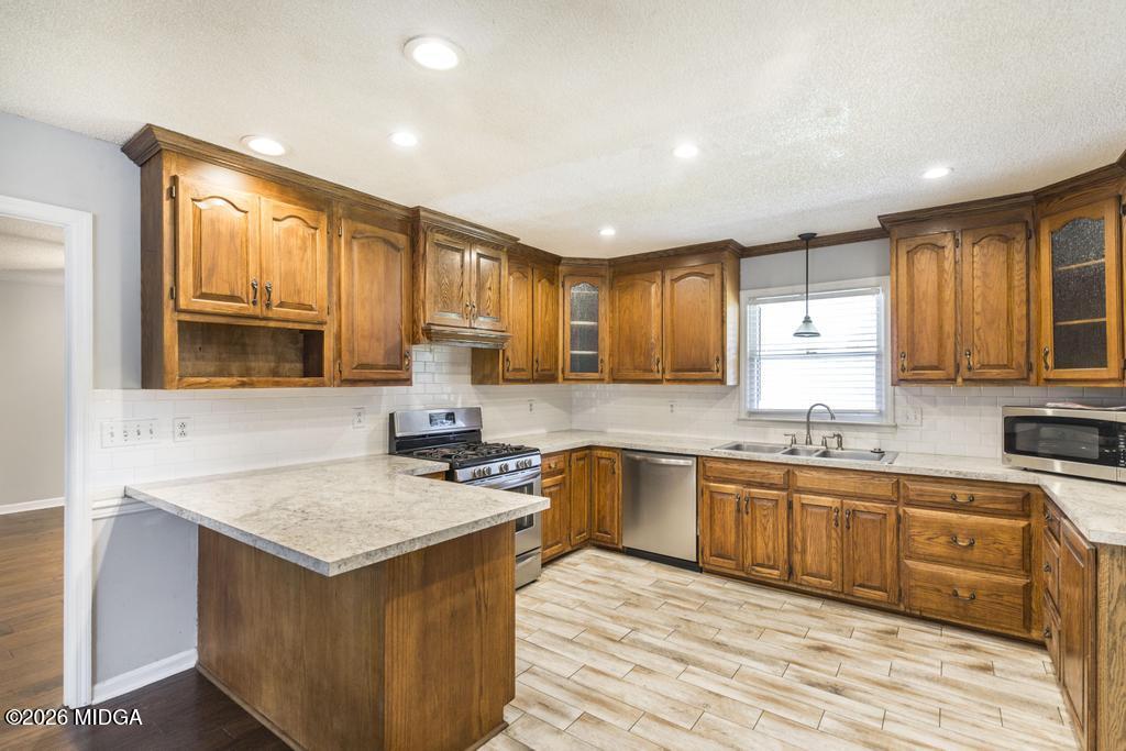3710 Sandy Circle Macon, GA 31216 - Photo 13 of 44 a kitchen with granite countertop a sink stove cabinets and wooden floor