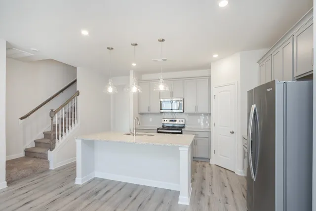 a kitchen with stainless steel appliances a refrigerator and a stove top oven