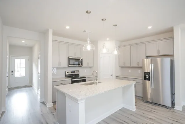 a kitchen with white cabinets and stainless steel appliances