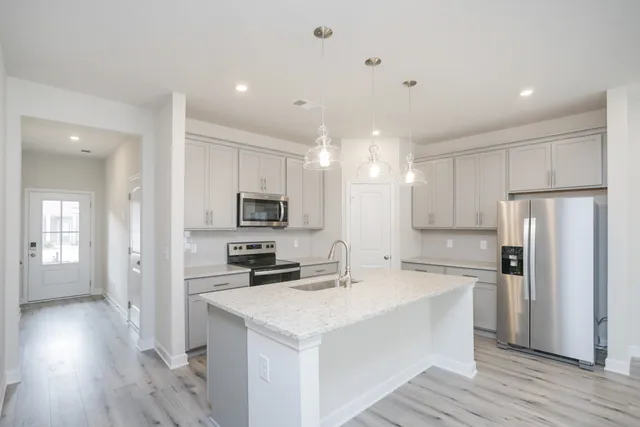 a kitchen with stainless steel appliances a refrigerator stove microwave and cabinets