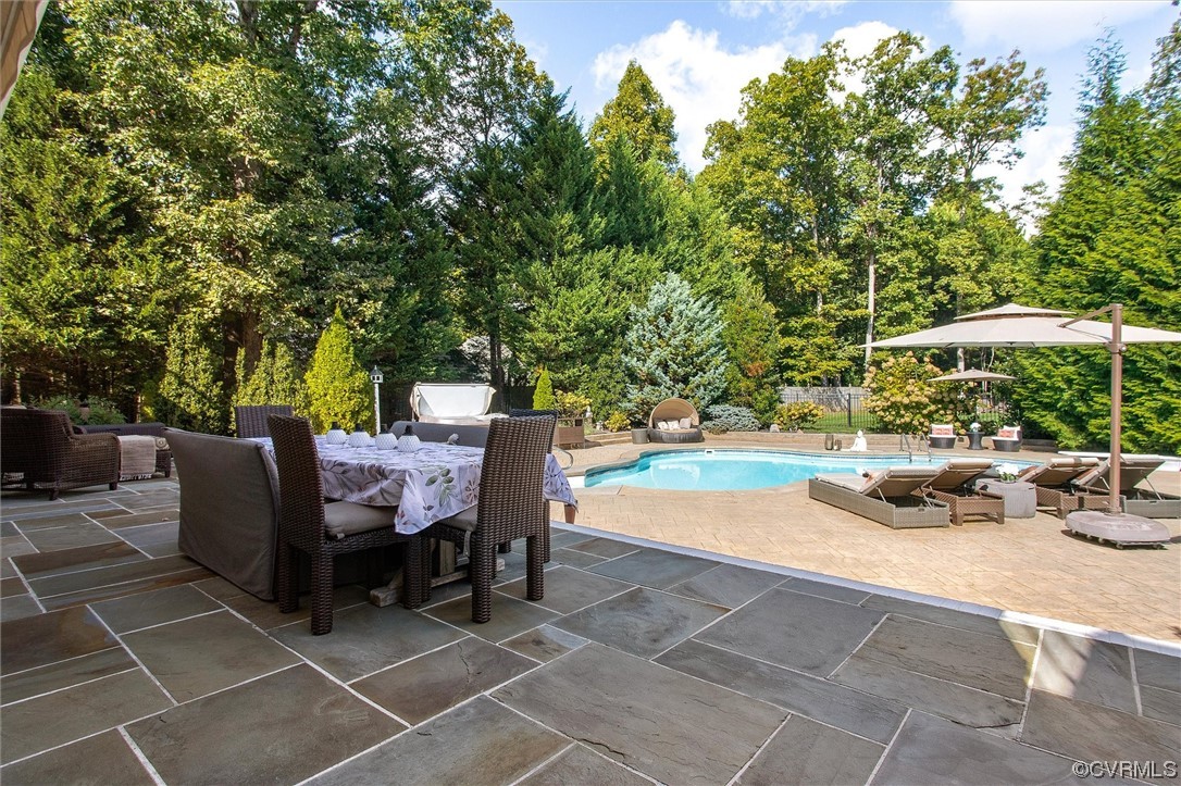 14440 Helmsley Road Midlothian, VA 23113 - Photo 39 of 50 a view of a patio with dining table and chairs under an umbrella