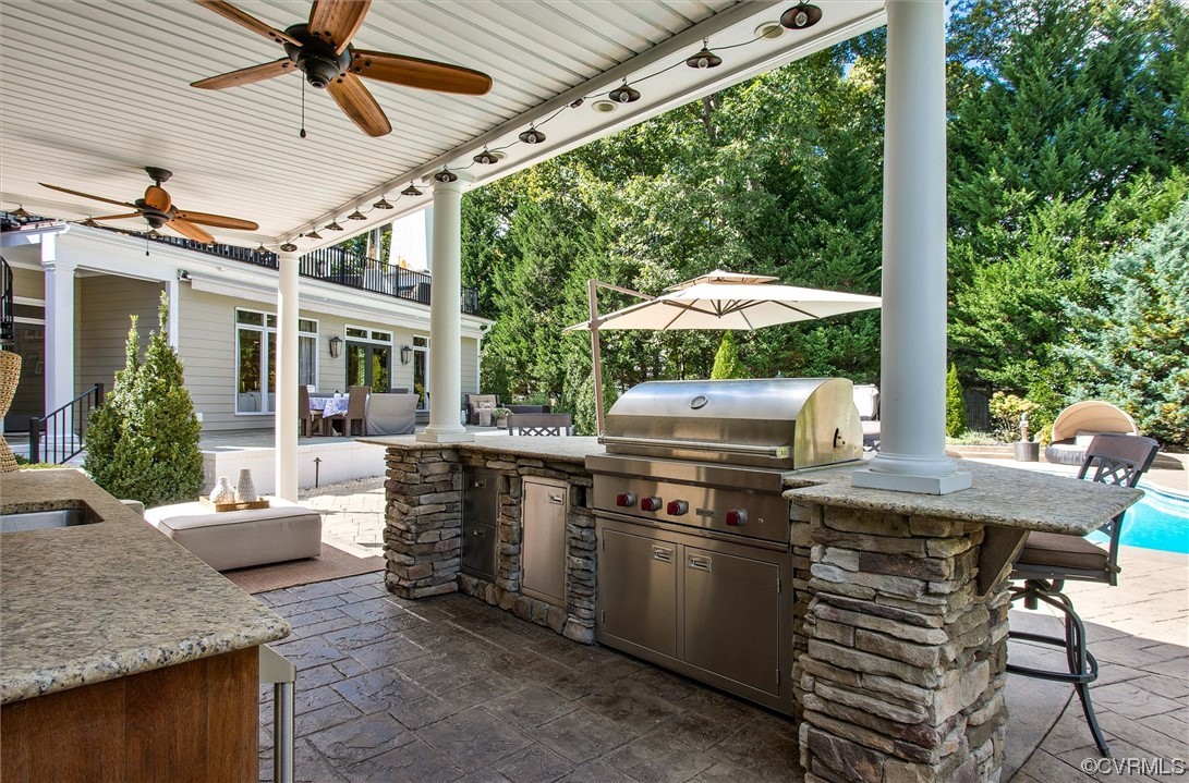 14440 Helmsley Road Midlothian, VA 23113 - Photo 42 of 50 a view of a patio with table and chairs under an umbrella