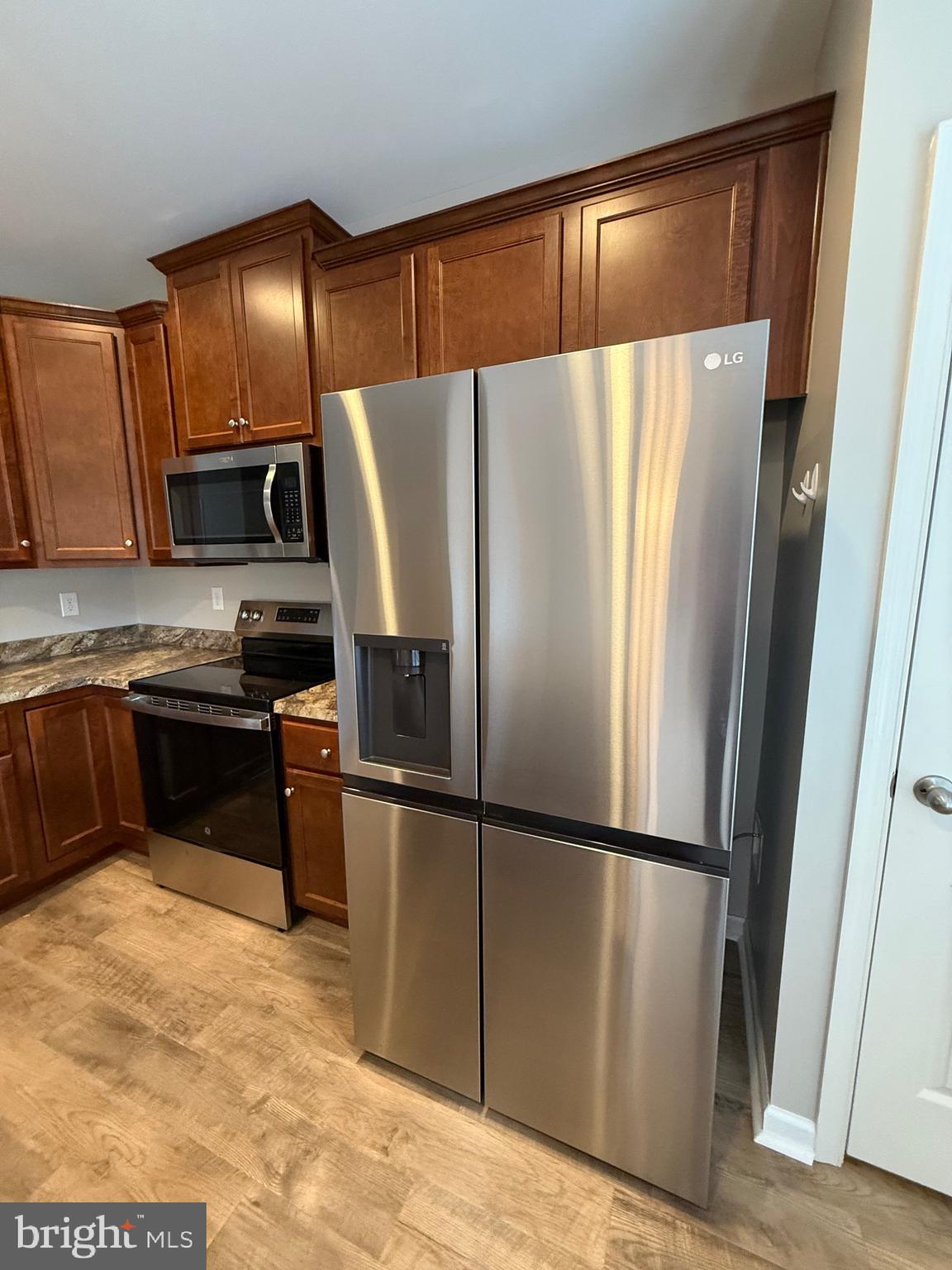 23 Landis Court Falling Waters, WV 25419 - Photo 17 of 45 a kitchen with granite countertop a refrigerator and a stove top oven